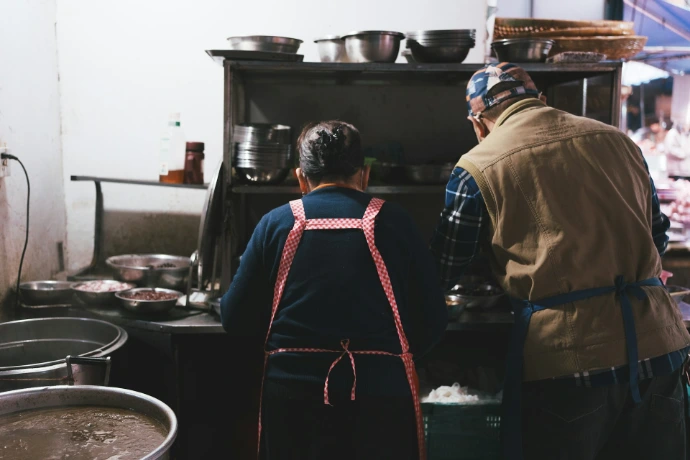Two people working in a busy kitchen.